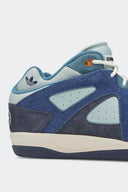 Detalle del talón del adidas BADBO 1.0 Night Navy: gamuza de pelo y trébol de adidas Originals