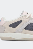 Detalle lateral del adidas BADBO 1.1 Chalk White: gamuza crema y malla gris oscuro
